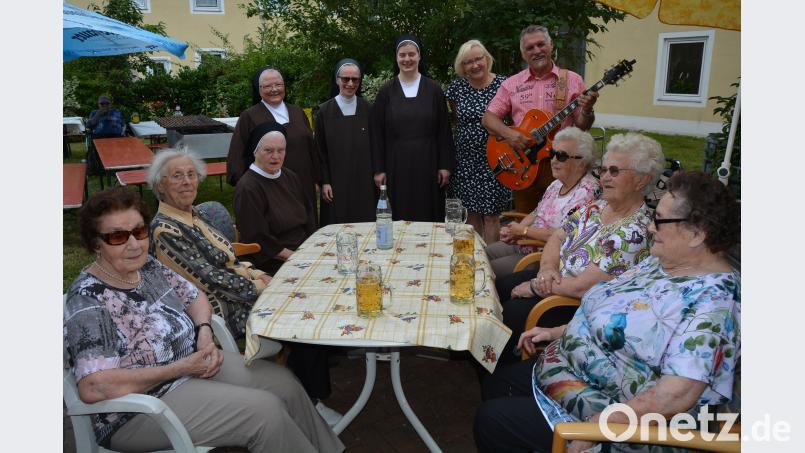 Musiker Anton Helgert (stehend, rechts) aus Püchersreuth unterhielt die Senioren mit einer Vielzahl an Stimmungsliedern. Direktorin Margit Küspert (stehend, 2. von rechts) freute sich, dass das Haus weiter voll belegt sei. Mit im Bild das Schwestern-Team um Oberin Hedwigis (sitzend, 3. von links). jr