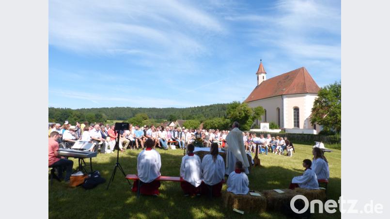 Die Besucherschar mit Pfarrer Roland Klein vor dem schmucken Kirchlein. fm