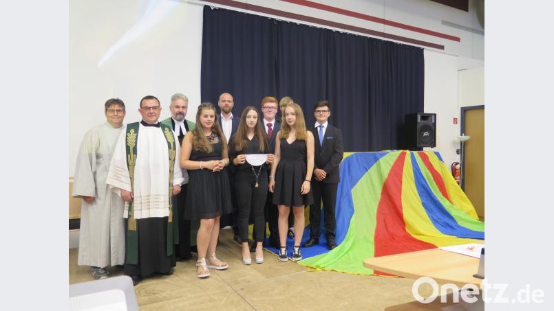 Gemeindereferent Jochen Gößl und die beiden Geistlichen Konrad Amschl und Dirk Grafe (von links) bedanken sich bei der Schulband und ihrem Leiter Christian Beck (hinten, Fünfter von links) für die Gestaltung des Gottesdienstes zur Schulentlassfeier. jzk