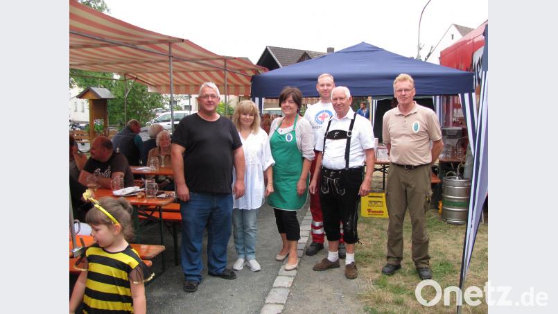 Hugo Diehl (rechts) organisiert den Wettbewerb im Pfunds-Stamm-Sägen. Platz eins geht an Dieter Nikol (links), gefolgt von Erna Hamm (Dritte von links) und Jan Diehl (Dritter von rechts) sei