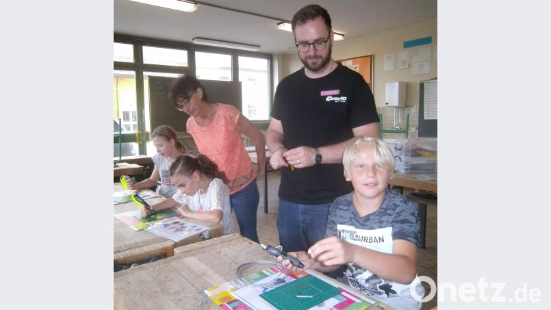 Nach der Einführung in das Thema 3-D-Druck konnten die Schüler ihre 3-D-Stifte ausprobieren und mit ihnen selbst künstlerisch tätig werden. Florian Ebner (stehend) vom Conrad-Education-Team hilft dabei. u