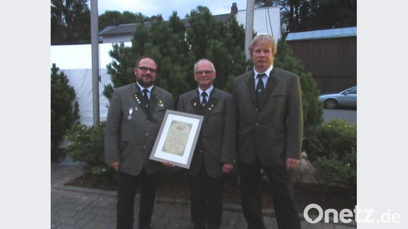 Vorsitzender und Schützenmeister Andreas Michl (links) und zweiter Schützenmeister Stefan Meyer (rechts) ernennen Martin Hönick zum Ehrenmitglied. gma