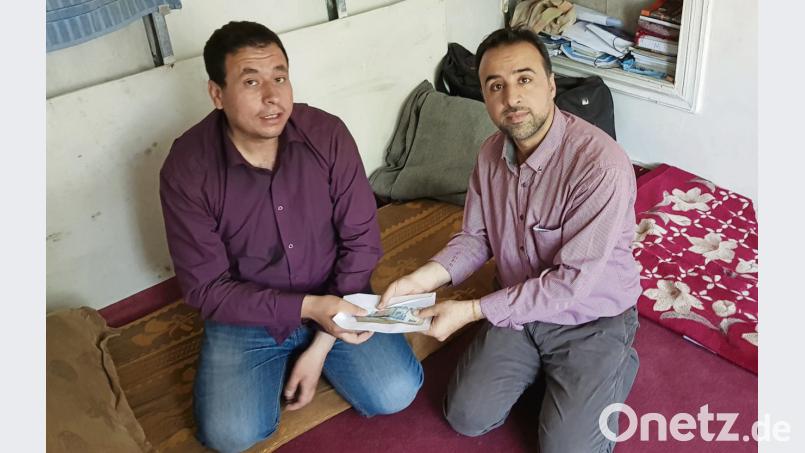 Dr. K. (rechts/Name aus Sicherheitsgründen abgekürzt), Mitarbeiter der Kinderhilfe Afghanistan, übergibt Abdullah I. einen Geldbetrag. jak