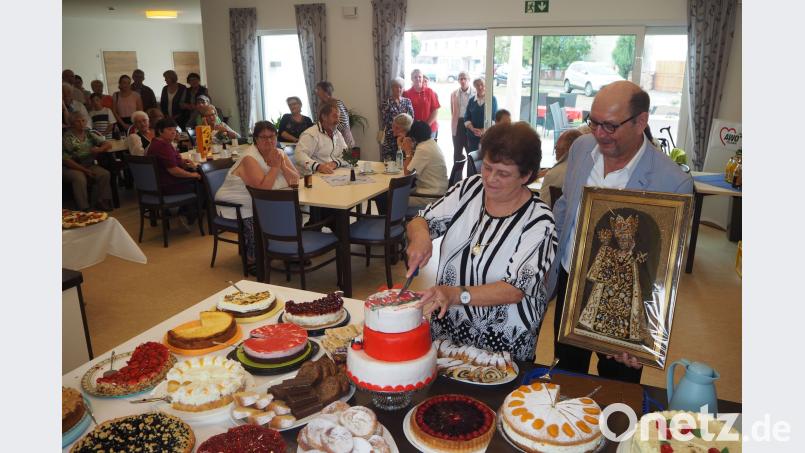 Die zweite Vorsitzende Anneliese Hierold überreicht an Vorsitzenden Fritz Möstl eine &quot;Schwarze Madonna&quot; und eröffnete mit dem Anschneiden der großen AWO-Torte das Buffet. gz