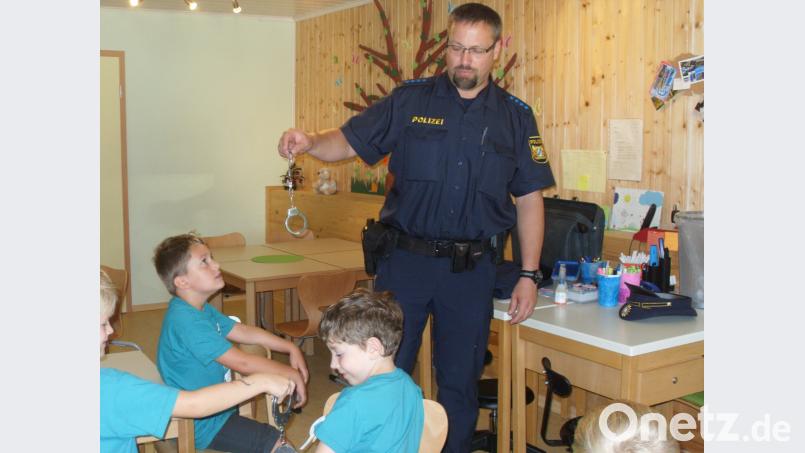 Polizist Carsten Landgraf zeigt den interessierten Vorschulkindern seine Ausrüstung. rpp