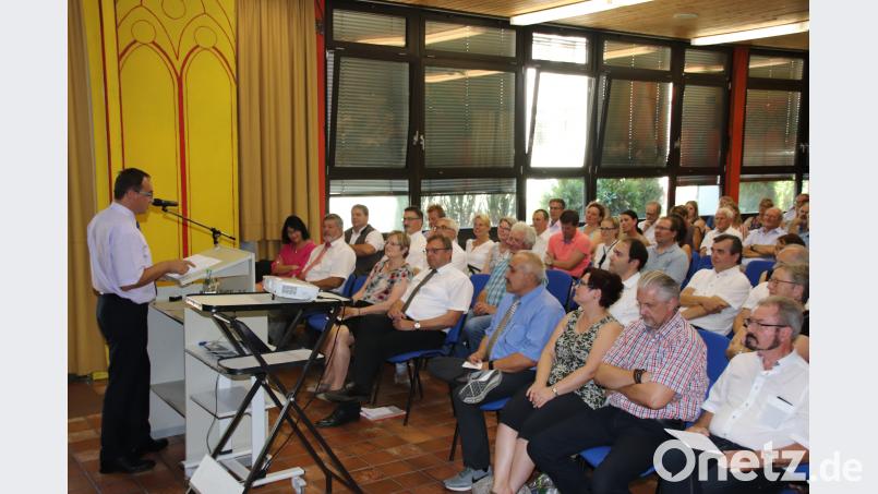 Großer Festakt in der Schule: Rektor Helmut Schuster (sitzend, Vierter von links) wird in den Ruhestand verabschiedet. Konrektor Manfred Bösl (am Pult) erinnert an dessen Leistungen. Thomas Dobler