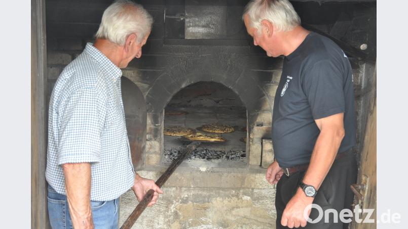 Leckere Zwiebelkuchen, Pizzen und Brot wurden aus den heißen Kohlen geholt. dob