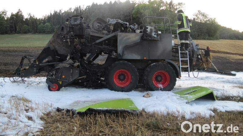Restlos ausgebrannt ist die Strohpressmaschine auf einem abgeernteten Feld. Polizei