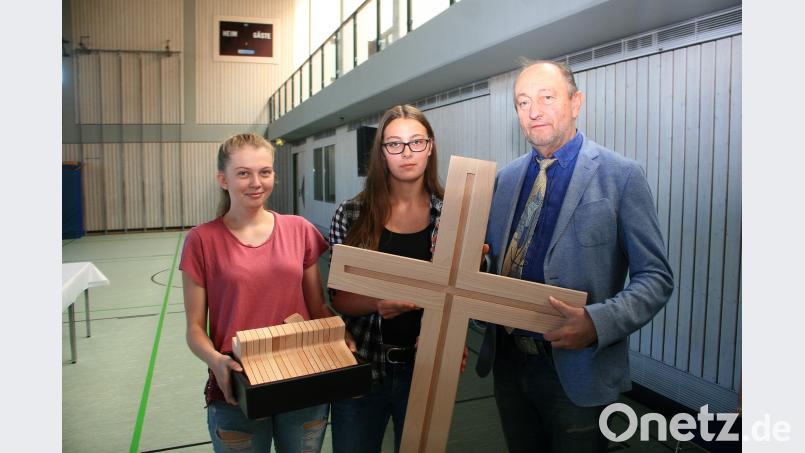 Lena Nemsow und Christina Miedl übergeben an Dr. Wolfgang Eckstein (von links) die von der Schreinerklasse angefertigten Kreuze. Sie werden zu Schuljahresbeginn gesegnet und anschließend in der Aula beziehungsweise in den Klassenzimmern des Beruflichen Schulzentrums angebracht. wro