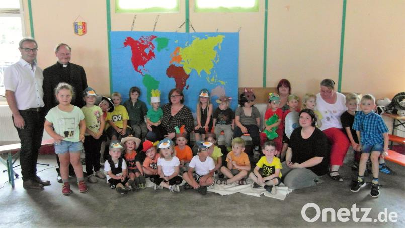 Bürgermeister Werner Nickl (von links) und Pfarrer Heribert Stretz sowie (hinten mitte sitzend) Leiterin Kerstin Dilling (hinten sitzend, Mitte) feiern mit den Buben und Mädchen das Kindergartenfest. hl