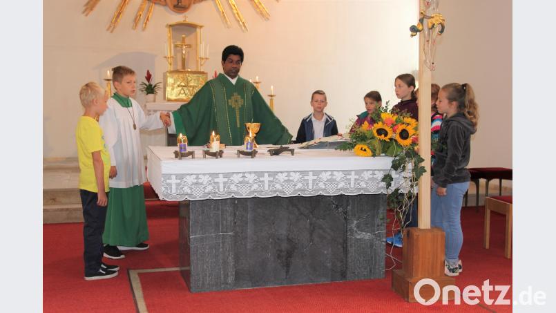 Zum „Vater unser“ standen alle Kinder gemeinsam mit Pater Charles um den Altar. Bild: ral