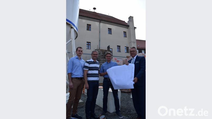 Hinterhalb vom historischen Rathaus tut sich was. Die Baustelle des Anbaus wächst langsam in die Höhe, vor allem ist bereits der Aufzugschacht im Hintergrund zu sehen. Azubi Nico Wiesend, Architekt Thomas Sticht, Stadtbaumeister Andras Ockl und Bürgermeister Franz Stahl (von links) machen sich ein Bild von der Baustelle. szl