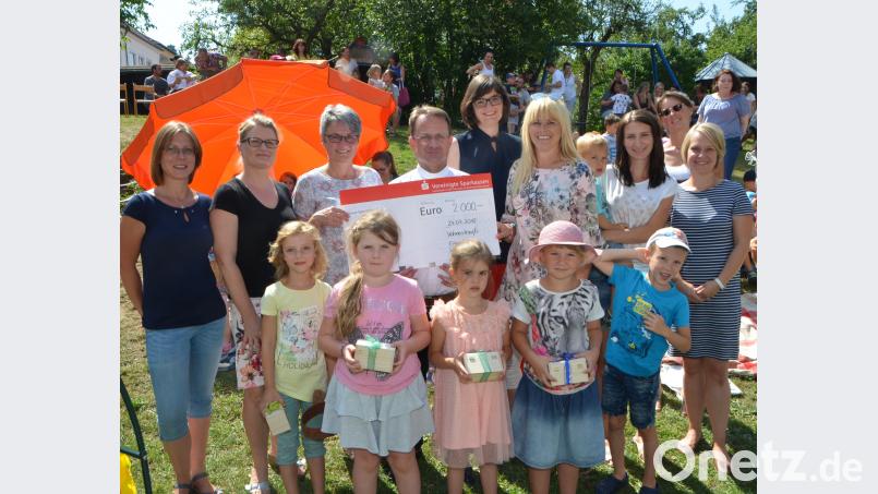 Dekan Alexander Hösl (Mitte) erhält vom Elternbeirat mit Vorsitzender Heidi Sollfrank (Zweite von links) zum Kindergartenjahresende einen Scheck über 2000 Euro, der für Spielzeug in der Einrichtung investiert werden soll. Das Geld erwirtschaftete das Gremium aus vielen Aktionen. dob