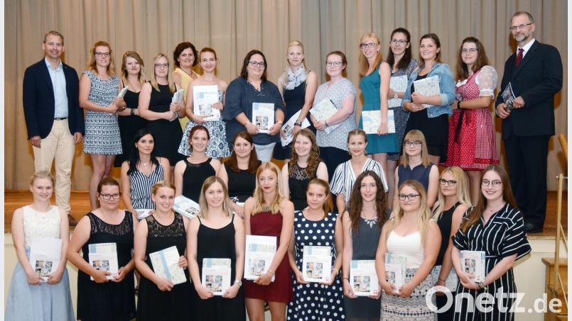 „Erzieher, des samma mia.“ Fachakademieleiter Karlheinz Binner (rechts), Stefan Schmidberger, Personalchef der Caritas Regensburg (links), und Pia Winter, Lehrkraft der Fachakademie (Fünfte von links), überreichen die Urkunden an die 28 Absolventinnen der Fachakademie. Gabi Schönberger