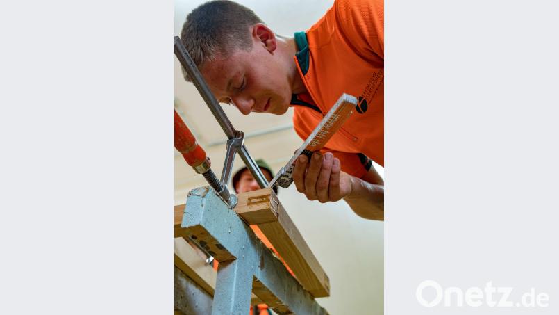 Aber genau! Azubi Jonas Plessgott montiert den Unterbau für die Holzbänke. exb