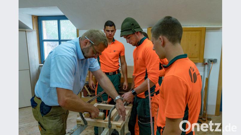 Schreinermeister Joachim Jungnickl (links) zeigt den angehenden Forstwirten des Forstbetriebs Fichtelberg den fachgerechten Zusammenbau der Bänke. exb