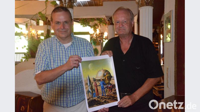 Uli Narr, der Vorsitzende des Weidener Comic-Clubs (links), und Perry-Rhodan-Experte Gerhart Renner gratulieren "Nick dem Weltraumfahrer" mit einem eigens angefertigten Poster zum 60. Geburtstag. Bild: Kunz Kunz