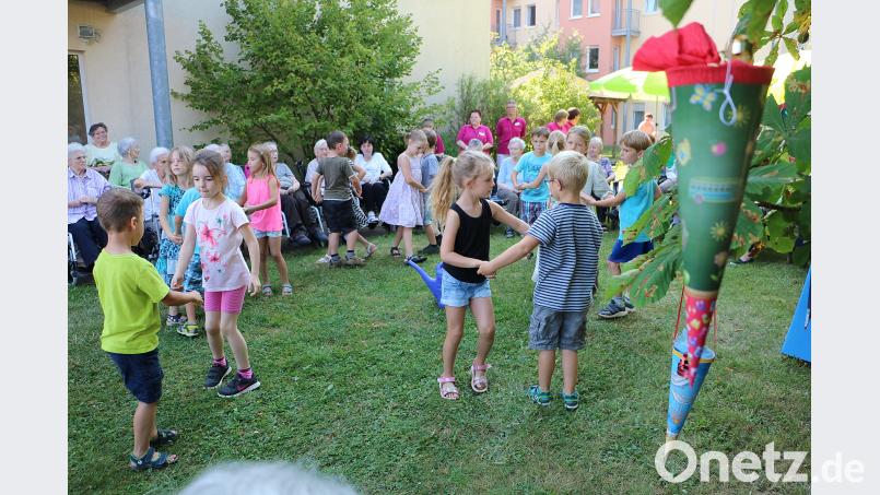 Die Heimbewohner schauen den Kindern bei ihren Tänzen am Zuckertütenbaum zu. gru