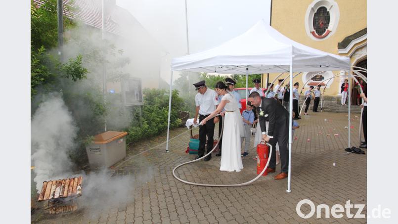Das kirchliche Ja-Wort geben sich Jürgen und Anja Liermann, geborene Scheidler in St. Ulrich in Wilchenreuth. Nach dem Durchschreiten eines Spaliers mit einer Schlauchrolle der Roschauer Feuerwehr bewies die Braut Geschick an der Kübelspritze. prh