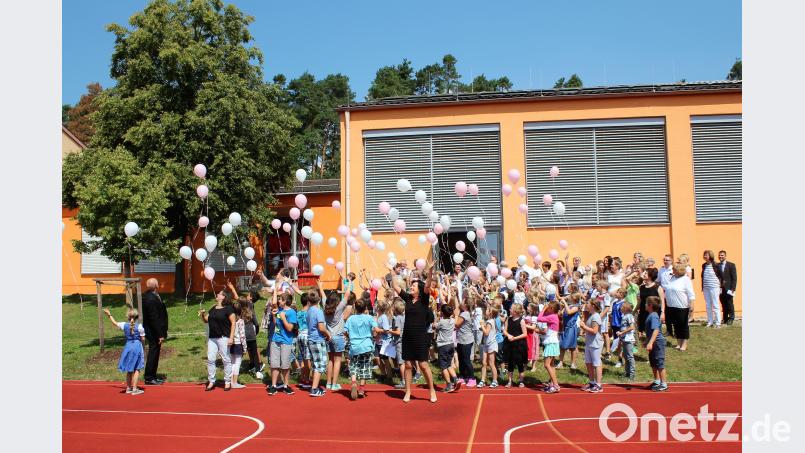 Schulkinder lassen Ballons mit guten Wünschen steigen wec