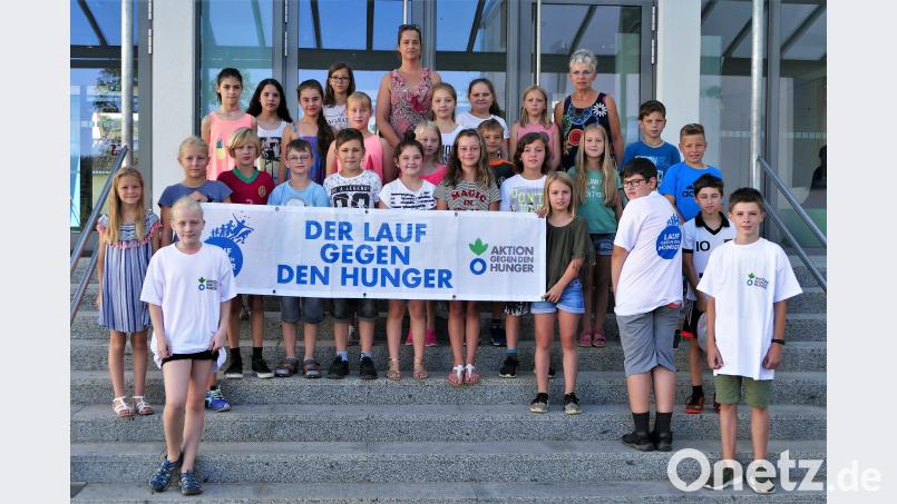 Die Klasse 4b, ihre Lehrerin Katrin Kaulbach und Rektorin Gunda Köstler präsentieren stolz das Logo der Hilfsorganisation, für das sich die Kinder mächtig ins Zeug gelegt haben. wbe