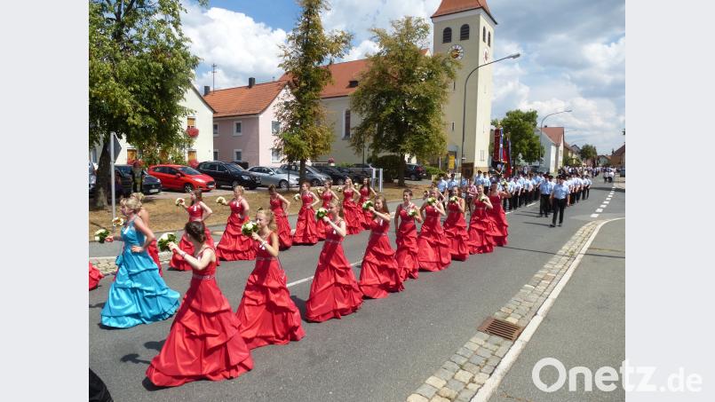 Blickfang beim Zug durch den Markt: Festmutter Daniela Kummer in charmanter Begleitung, dahinter die Jubelwehr mit neuer und alter Fahne. bk