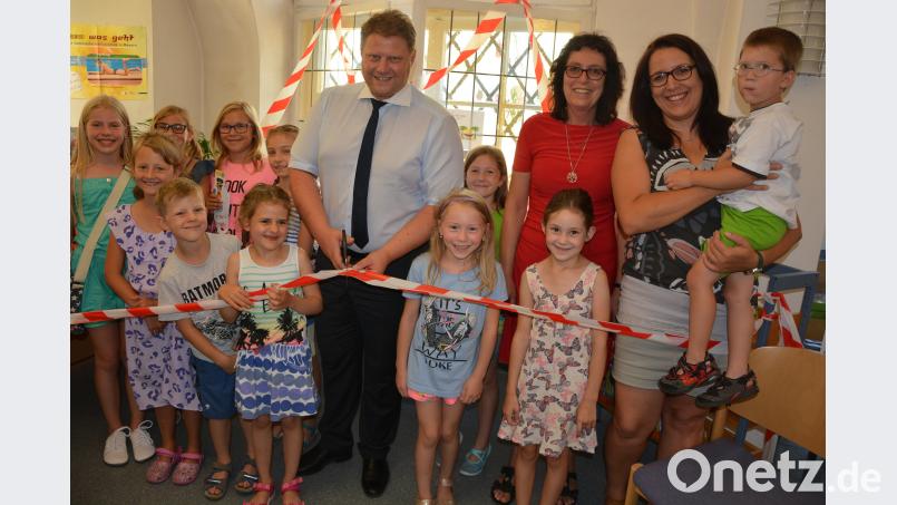 Zum Auftakt des Sommerferien-Leseclubs durchschnitt 2. Bürgermeister Stefan Grillmeier das Band zu den 160 Kinder- und Jugendbüchern. Mit dabei Büchereileiterin Viola Rieß und Projektleiterin Sandra Schug (rechts), sowie die erwartungsvollen Kinder. jr