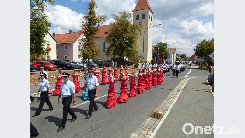 Blickfang beim Zug durch den Markt: Festmutter Daniela Kummer in charmanter Begleitung, dahinter die Jubelwehr mit neuer und alter Fahne. bk