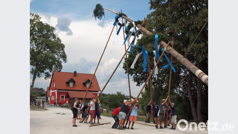 Bei drückender Schwüle stellen die „Wolfsbecker“ ihren Kirwabaum auf. Kaum geschafft, öffnet der Himmel seine Schleusen. sön