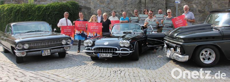 Für das Altstadtfest am 18./19. August rühren Bürgermeister Martin Birner (links), Tourismusamtsleiter Werner Dietrich (rechts), Vertreter der beteiligten Vereine, Sponsoren und Medienpartner die Werbetrommel. Als Kulisse für die Programm-Präsentation waren (von rechts) ein GMC 1000, eine Corvette C1 (Baujahr 1959) und ein Cadillac DeVille (1961) auf dem Brandplatz vorgefahren. mp