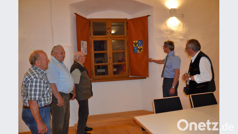 Die Wappenvorhänge im Saal eignen sich zu einem Gang durch die Burg- und die Schlossgeschichte und ermöglichen Lichtbildervorträge auch während der Tageszeit. Mitglieder des Vorstands des Fördervereins sehen sich mit Bürgermeister Hermann Ach die Wappen an. gi