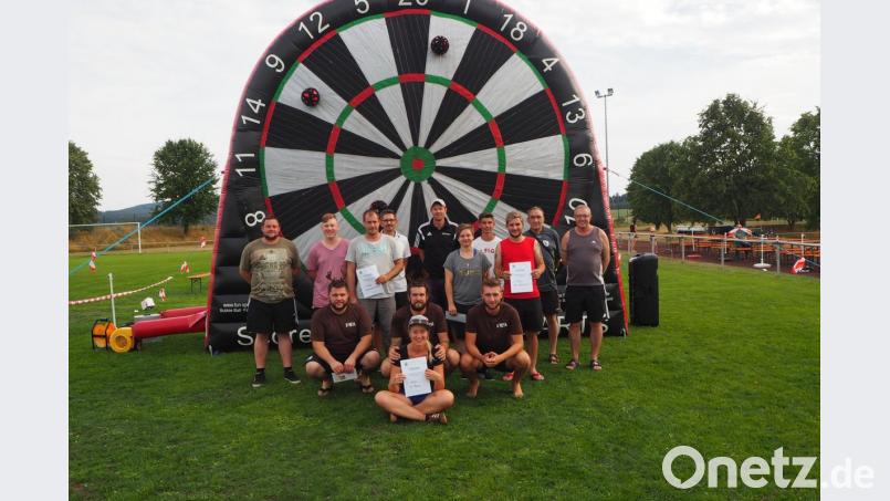 Die Organisatoren des TSV-Fördervereins gratulieren dem besten Fußballdartteam „D´Reya“ mit Daniel Meckl, Pascal Liebl und Christian Ach (von links) mit ihrer Glücksbringerin Carina und dem Bayernfanclub Pfrentsch und Dartfreunden Eslarn zu ihren guten Platzierungen. gz