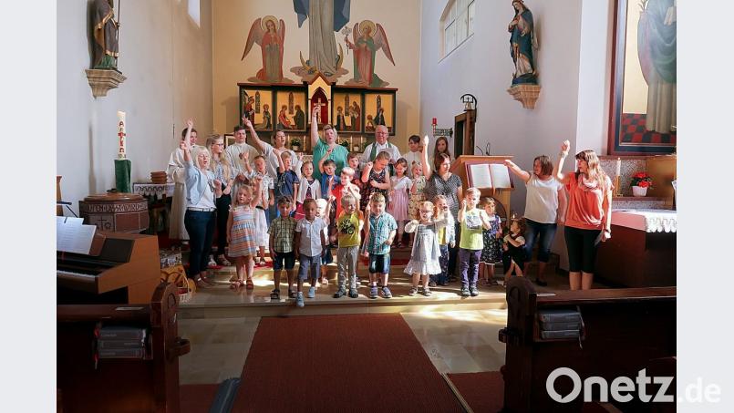 Mädchen und Buben des Kinderhauses Friedenfels gestaltete zusammen mit Priester Siegfried Wölfel (hinten) einen Familiengottesdienst und verabschiedete sich vor der gesamten Kirchengemeinde in die Ferien. Kindergartenleiterin Nicole Lippert (hinten Mitte) dankte den Geistlichen. bsc