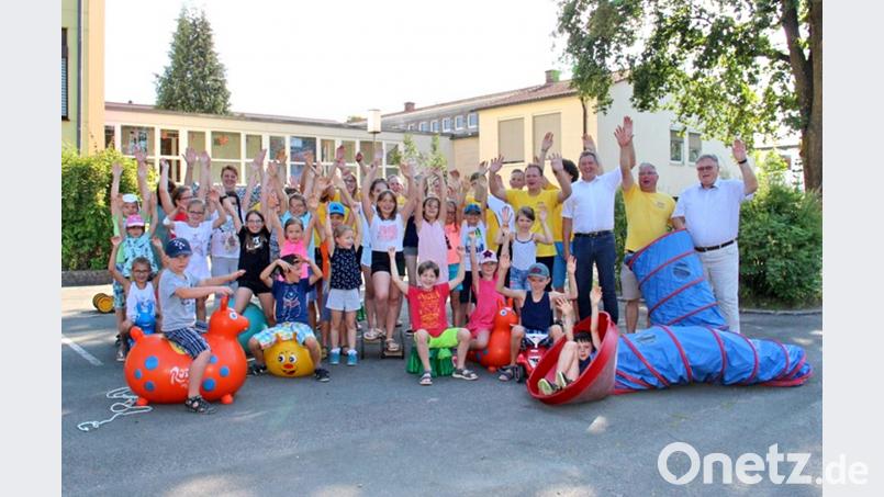 Zum Tourauftakt des Spielmobils kommen nicht nur viele Kinder, sondern auch Bürgermeister Manfred Porsch (rechts), Landrat Hermann Hübner (Dritter von rechts) und Kreisjugendring-Vorsitzender Christian Porsch (stehend, Fünfter von rechts) zur Werner-Porsch-Schule. hai