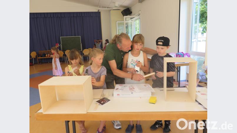 Betreuer Uwe Pleschke hilft den Mädchen und Buben beim Bauen von Cajons. jzk