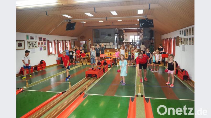 Sportwart Thomas Hacker erklärt den Kindern und Jugendlichen das Kegeln. gz