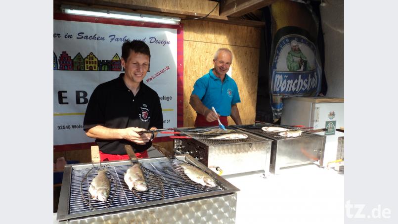 Die Grillspezialisten bei der Zubereitung der Forellen. ksi