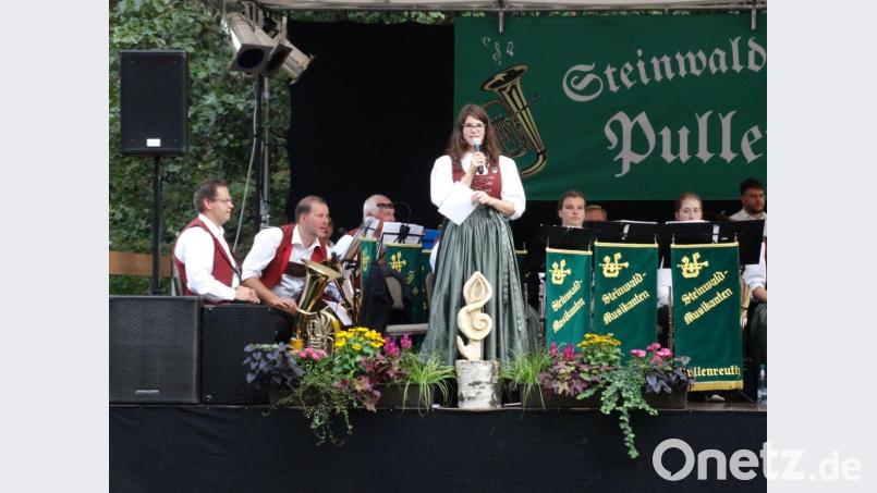 Auf der mit Blumen dekorierten Bühne stimmt Vorsitzende Marina Scherm das Publikum auf das Programm mit böhmischer Blasmusik ein. twg