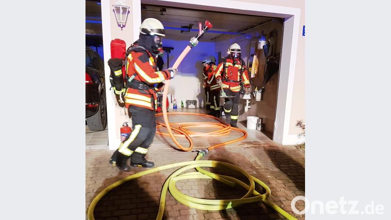 Unter Atemschutz gehen die Feuerwehrleute vor. Zur Sicherheit nehmen sie ein Strahlrohr mit das jedoch nicht zum Einsatz kommt. In Schuttmulden bringen sie das Brandgut aus dem Haus, damit es im Außenbereich abgelöscht wird. mde
