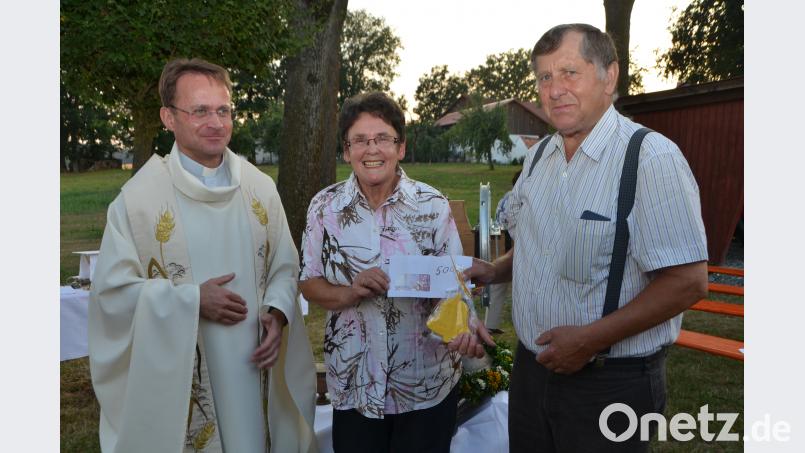 Christa Wildenauer übergibt im Beisein von Dekan Alexander Hösl an "den Vater des Glockenturmprojekts" Alfred Uschold 500 Euro. dob