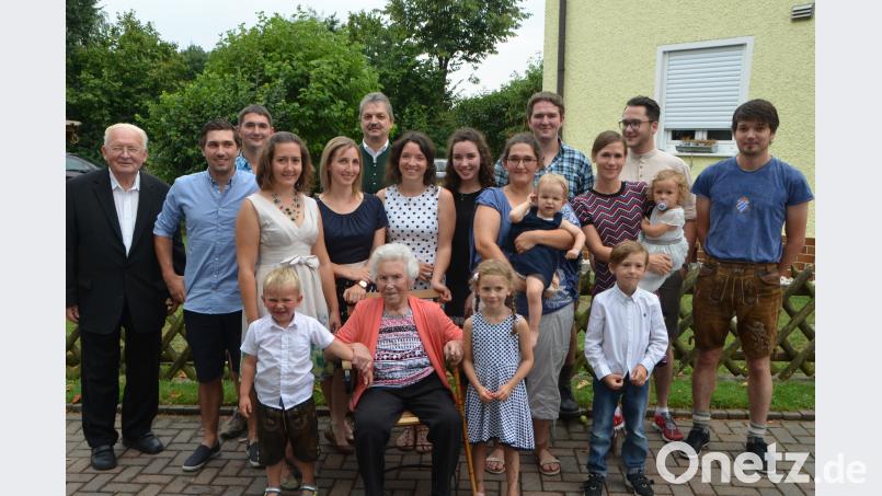 Cäcilia Mitlmeier feiert 90. Geburtstag und schart ihre Enkel und Urenkel um sich. Pfarrer Gerhard Schmidt (links) und Bürgermeister Andreas Wutzlhofer (hintere Reihe, Mitte) gratulieren zu dem gesegneten Alter ebenfalls. dob