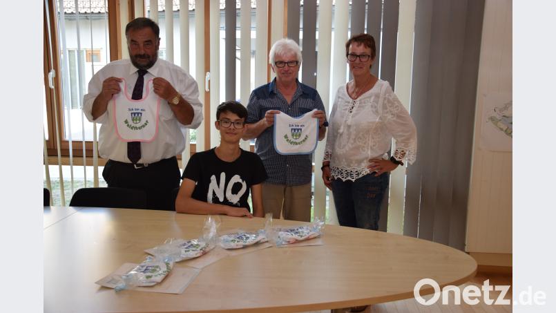 Bürgermeister Josef Beimler (links) und Kämmerer Josef Götz (Zweiter von rechts) präsentieren die Geschenke für die Neugeborenen. Praktikant Tobias Sollfrank (sitzend) fertigte passende Urkunden und Petra Reil (rechts) verpackte die Lätzchen. fla