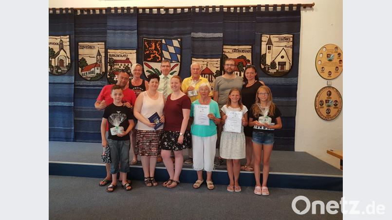 Bürgermeister Hermann Ach (2. Reihe, Zweiter von links) ehrt für den 25. Aufenthalt Manuela Welland und weitere Urlaubsgäste für den fünften Aufenthal. gi