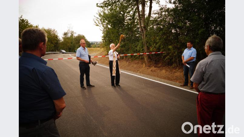 Stadtpfarrer Josef Häring segnet die neue Straße. arw