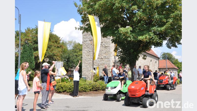 Auch einige Rasentraktoren fahren in Kleinschwand bei der Segnung beim Kirchenfest an Pfarrer Wilhelm Bauer vorbei. es