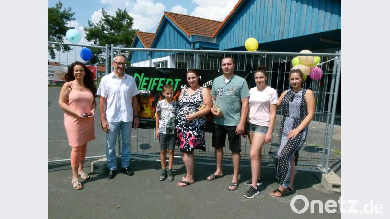 Ein breites Band wirbt für die neue Firma. Marita Gradl vom Gewerbeverein und zweiter Bürgermeiste rKarl Lorenz (von links) gratulierten mit Sekt der Familie Neifert (von links Dennis, Vera, Viktor, Elena und Julia) zur Geschäftseröffnung. rn
