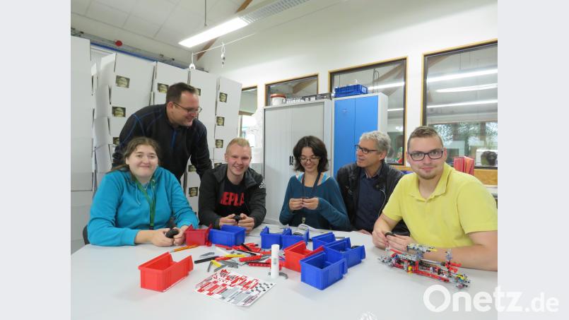 Gemeinsam macht es mehr Spaß: Johannes Kolb (Dritter von links) und Werkstattleiter Jürgen Hahn (Zweiter von links) zeigen Magdalena Fischer (links), Franziska Winkler (Dritter von rechts) und Jakob Dutz (rechts) wie die Bausteine zusammengefügt werden. Mit im Bild FOS-Lehrer Harald Fritsch (Zweiter von rechts). ubb