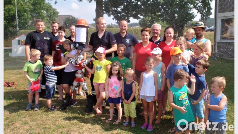 Heiß, kalt und spritzig ging es zu beim Ferienprogramm der Feuerwehr. „Sam“, der Blechkamerad (mit rotem Helm), lacht ebenso begeistert wie 		die Kinder und Feuerwehr-Verantwortlichen. jml