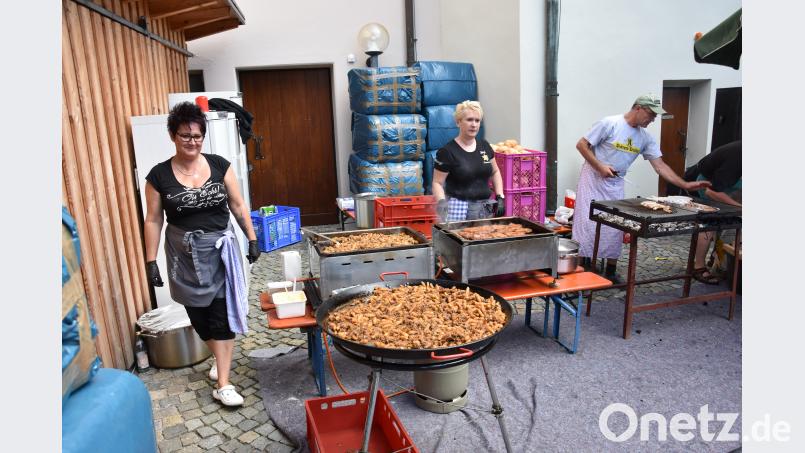 Schupfnudeln mit Kraut brutzeln in der großen Pfanne, Steaks und Bratwürste auf dem Grill. ui