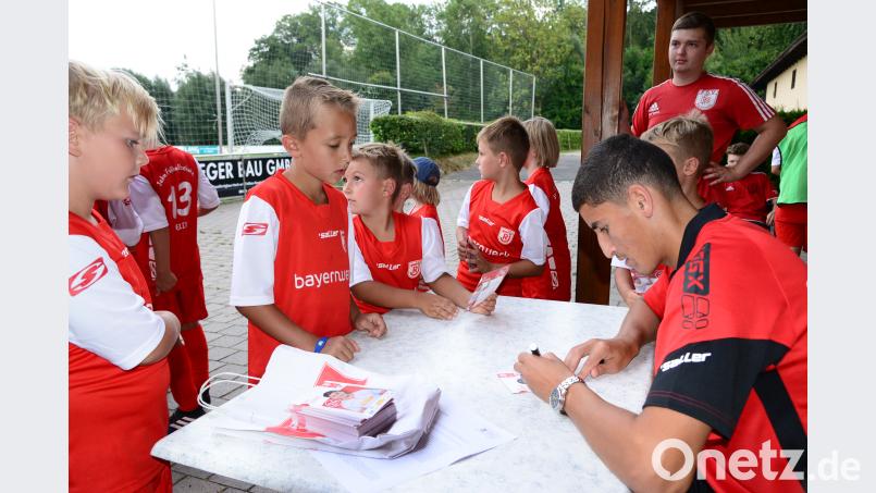 Fußballprofi Ali Odabas vom SSV Jahn Regensburg hat für die Kinder viele Autogrammkarten mitgebracht, die er auch gern unterschreibt. bey